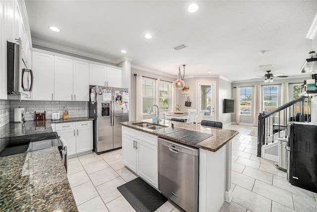 kitchen featuring white cabinetry, a kitchen island with sink, sink, and stainless steel appliances