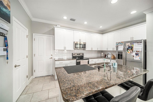 kitchen featuring white cabinets, sink, a breakfast bar area, an island with sink, and stainless steel appliances