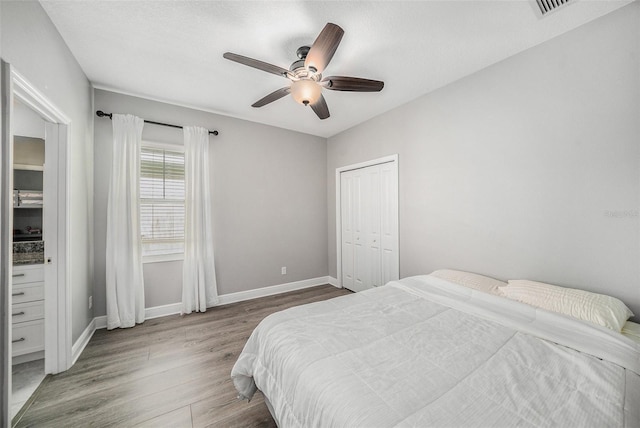 bedroom featuring ceiling fan, a closet, and wood-type flooring