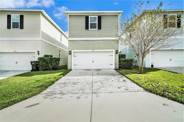 view of property featuring a front yard and a garage