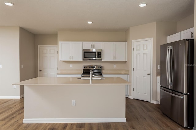 kitchen featuring sink, dark wood-type flooring, a center island with sink, white cabinets, and appliances with stainless steel finishes