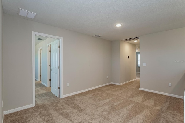 unfurnished room with light carpet and a textured ceiling