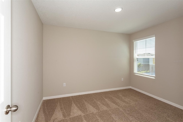 unfurnished room featuring carpet flooring and a textured ceiling