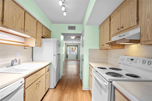 kitchen featuring white appliances, light hardwood / wood-style floors, tasteful backsplash, rail lighting, and sink