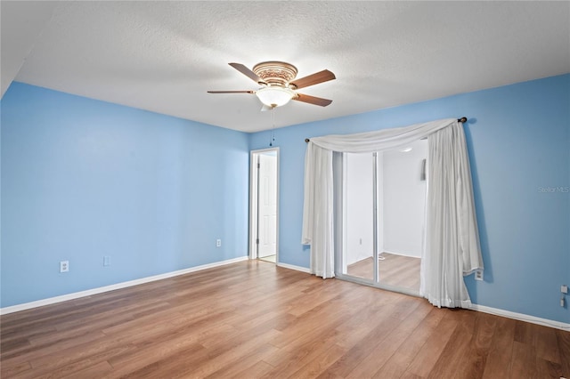 unfurnished bedroom with ceiling fan, a textured ceiling, and hardwood / wood-style flooring