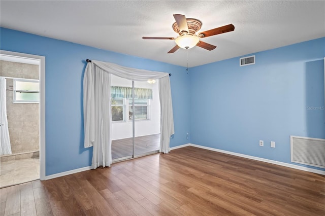 spare room featuring hardwood / wood-style flooring, ceiling fan, and a wealth of natural light