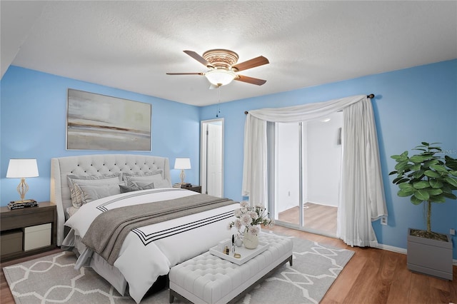 bedroom featuring a textured ceiling, ceiling fan, and wood-type flooring