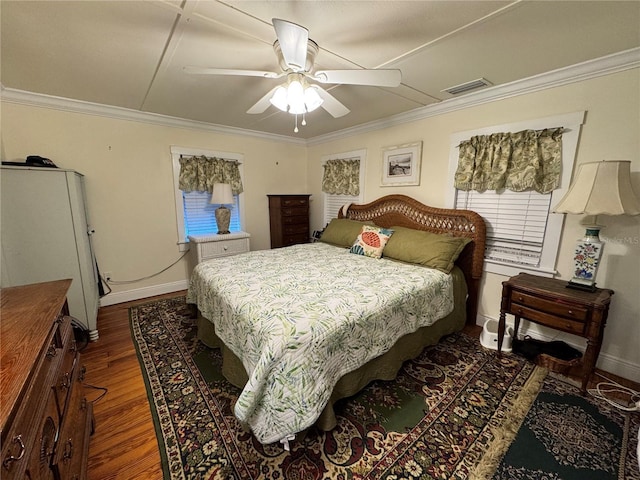 bedroom with ceiling fan, crown molding, and dark wood-type flooring