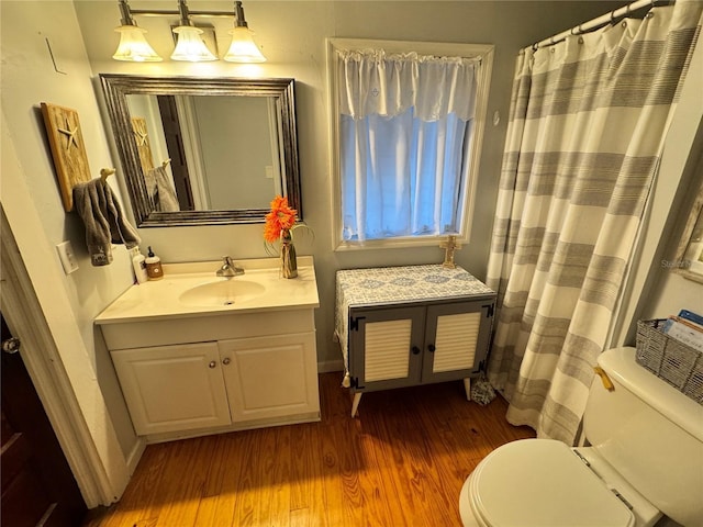 bathroom featuring a shower with shower curtain, hardwood / wood-style floors, vanity, and toilet