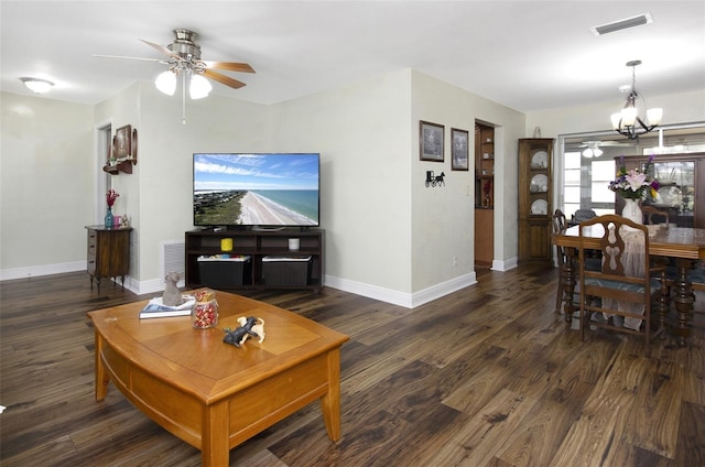 living room featuring ceiling fan with notable chandelier and dark hardwood / wood-style flooring