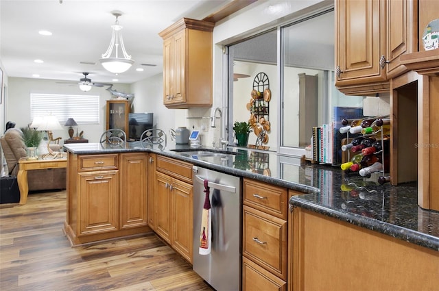 kitchen with dark stone counters, sink, light hardwood / wood-style flooring, stainless steel dishwasher, and kitchen peninsula