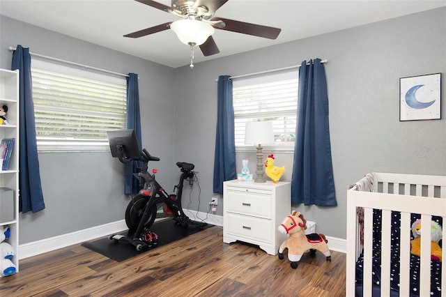 workout area with ceiling fan and dark wood-type flooring