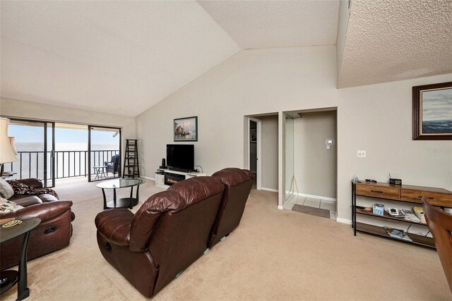 carpeted living room featuring vaulted ceiling, a water view, and a textured ceiling