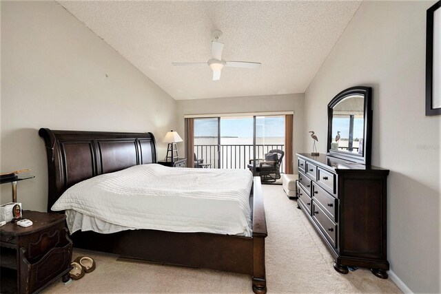 carpeted bedroom with ceiling fan, access to exterior, vaulted ceiling, and a textured ceiling