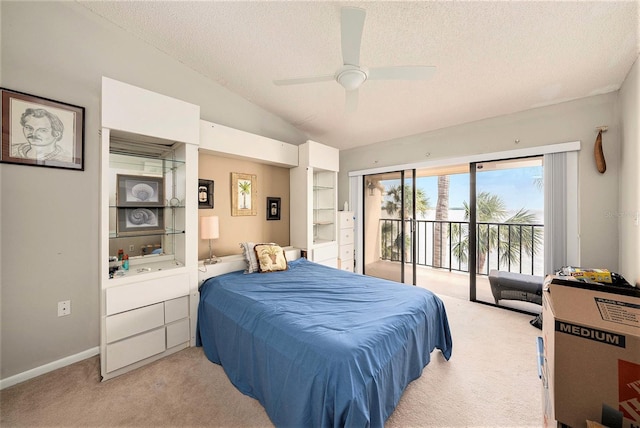 carpeted bedroom with ceiling fan, vaulted ceiling, a textured ceiling, and access to outside