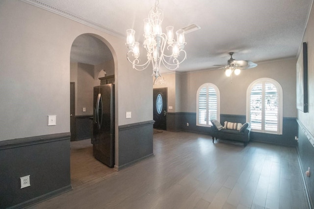 kitchen featuring stainless steel fridge, ceiling fan with notable chandelier, dark hardwood / wood-style flooring, and crown molding