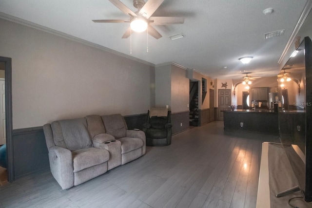 living room with wood-type flooring, ceiling fan, and ornamental molding