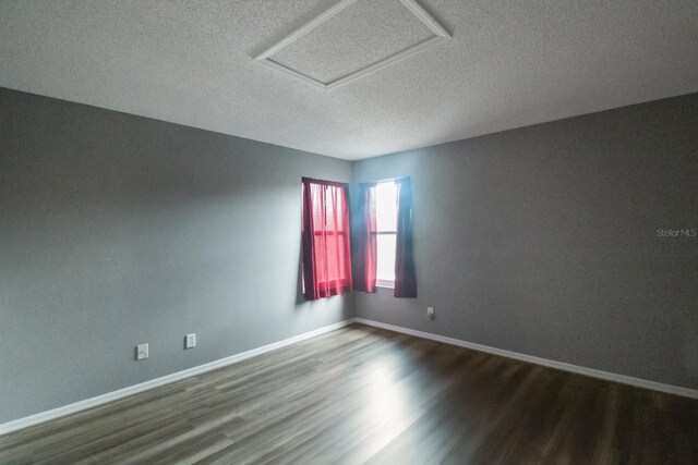 unfurnished room featuring hardwood / wood-style floors and a textured ceiling