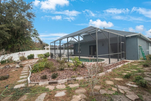 back of house with a fenced in pool and a lanai