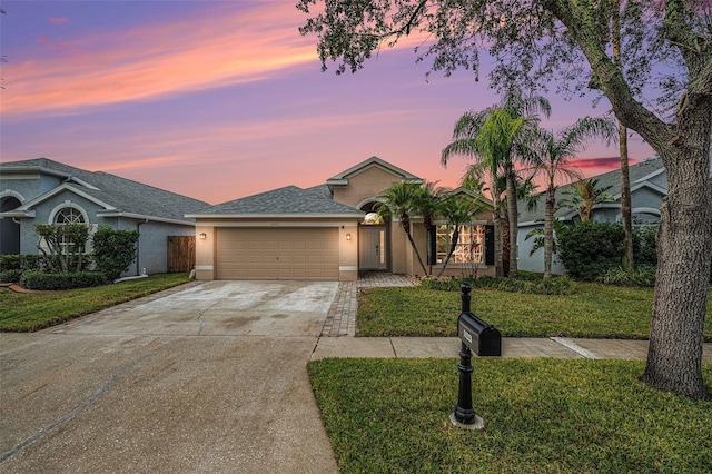 ranch-style house with a yard and a garage