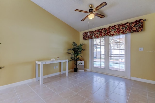 spare room with light tile patterned floors, baseboards, ceiling fan, and vaulted ceiling