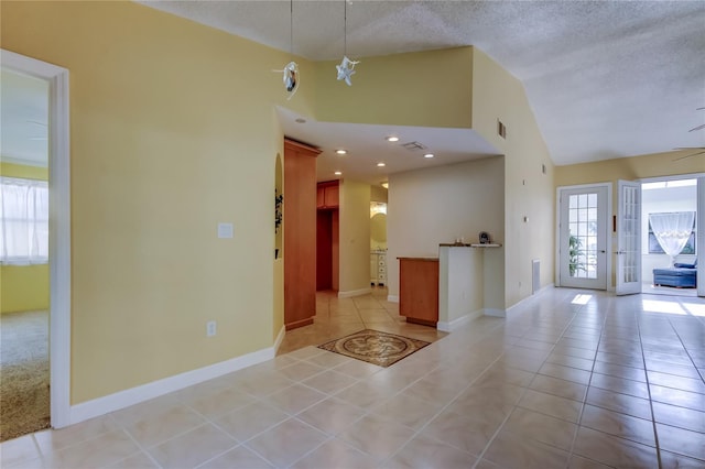 interior space with recessed lighting, baseboards, a textured ceiling, and light tile patterned flooring