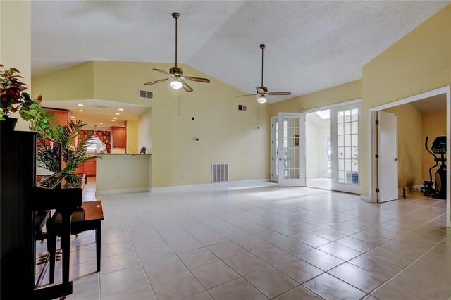 living area featuring light tile patterned flooring, french doors, visible vents, and high vaulted ceiling