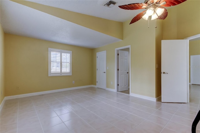 unfurnished bedroom featuring light tile patterned floors, visible vents, baseboards, and ceiling fan