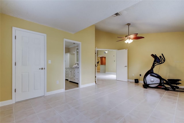 exercise room with light tile patterned floors, baseboards, visible vents, ceiling fan, and vaulted ceiling