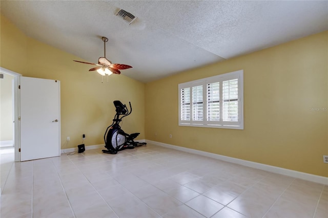 exercise area featuring vaulted ceiling, baseboards, visible vents, and a textured ceiling