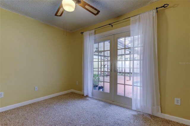 carpeted empty room featuring french doors, baseboards, a textured ceiling, and a ceiling fan