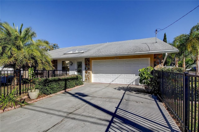 ranch-style home with a garage, concrete driveway, and fence