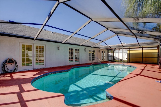 pool with glass enclosure, a patio area, and french doors