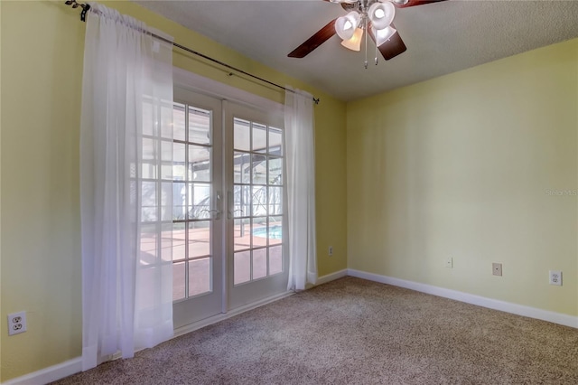 spare room featuring french doors, baseboards, carpet, and a ceiling fan