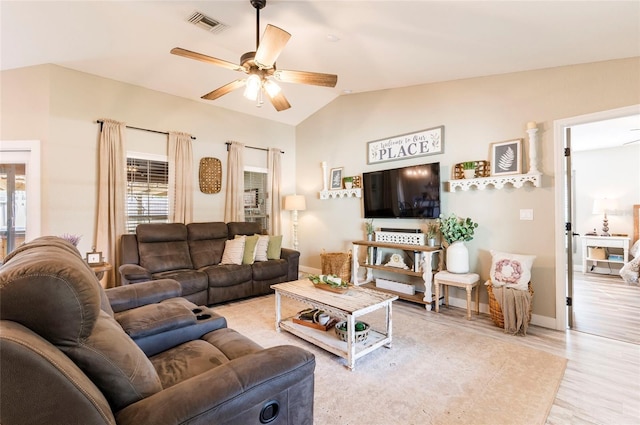 living room featuring ceiling fan, light hardwood / wood-style flooring, and vaulted ceiling