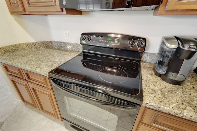 kitchen featuring electric range, light tile patterned floors, and light stone counters