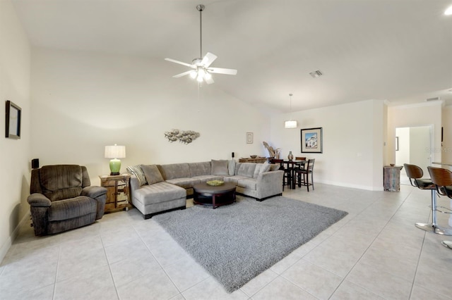 tiled living room with ceiling fan and high vaulted ceiling