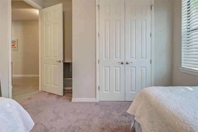 bedroom with light colored carpet and a closet