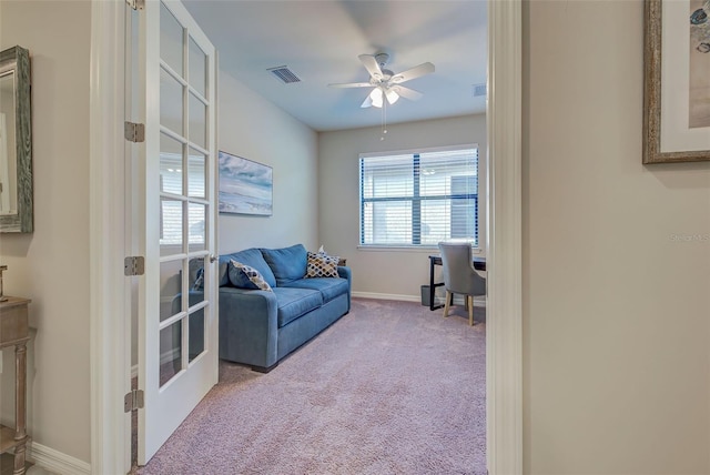 living area featuring ceiling fan, french doors, and light colored carpet