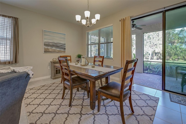 tiled dining room featuring a wealth of natural light and ceiling fan with notable chandelier