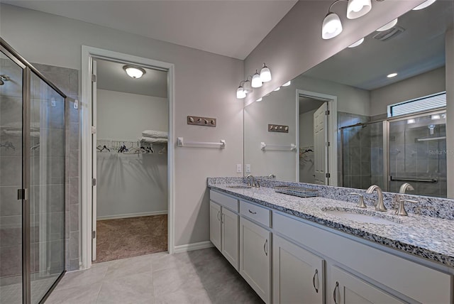 bathroom featuring tile patterned flooring, vanity, and an enclosed shower