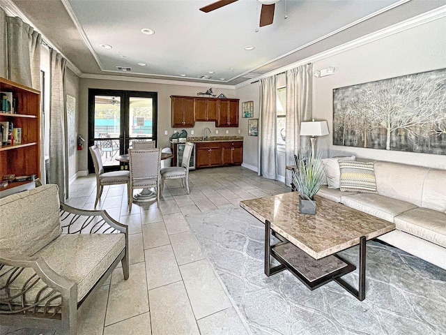 tiled living room with ceiling fan, sink, french doors, and ornamental molding