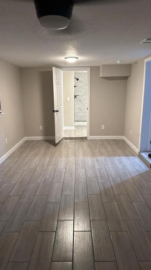 empty room with hardwood / wood-style floors and a textured ceiling