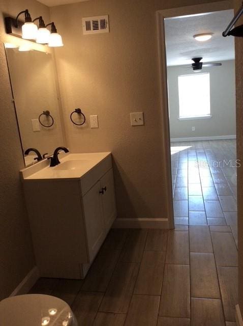 bathroom with vanity, ceiling fan, toilet, and wood-type flooring