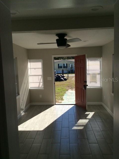 doorway to outside featuring ceiling fan and dark hardwood / wood-style flooring