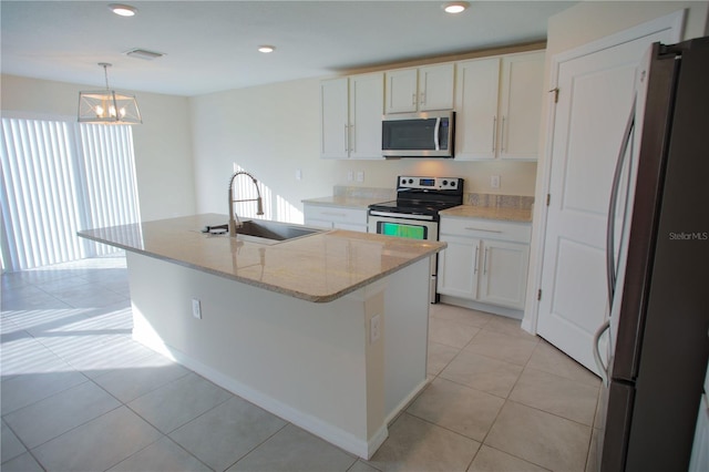 kitchen featuring white cabinets, sink, hanging light fixtures, an island with sink, and appliances with stainless steel finishes