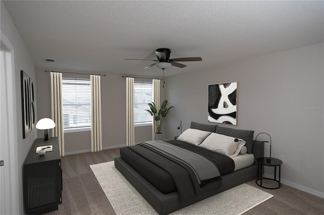 carpeted bedroom with a textured ceiling and ceiling fan