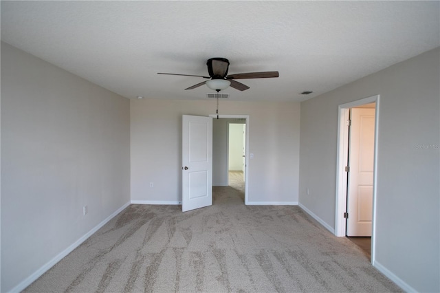 carpeted empty room with ceiling fan and a textured ceiling