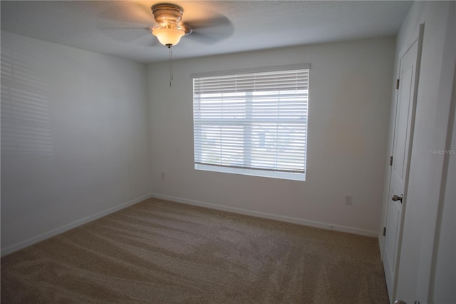 carpeted spare room with ceiling fan