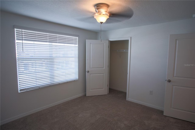 unfurnished bedroom featuring carpet flooring, ceiling fan, and a closet